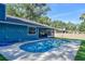 A refreshing backyard pool surrounded by concrete, adjacent to a vibrant blue home at 2855 Se 38Th St, Ocala, FL 34480