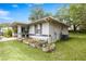 Exterior side view of home featuring garden beds and a well-kept lawn area at 329 Larch Rd, Ocala, FL 34480