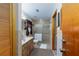 Well-lit bathroom featuring a walk-in shower, vanity sink, and ample storage with wooden cabinets at 3427 Se 137Th St, Summerfield, FL 34491