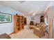 Cozy living room featuring carpet flooring, bookshelves, and comfortable seating at 3427 Se 137Th St, Summerfield, FL 34491
