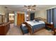Cozy main bedroom featuring a ceiling fan, ensuite bathroom, and a spacious closet with ample storage at 3427 Se 137Th St, Summerfield, FL 34491