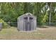 Backyard storage shed with solar panels and double doors, set within a fenced yard at 3427 Se 137Th St, Summerfield, FL 34491