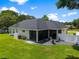 Aerial view showcases the home's backyard with a screened patio, fire pit, and manicured lawn at 3883 Se 51St Ct, Ocala, FL 34480