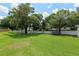 Spacious back yard featuring lush green lawn, mature trees, and a privacy fence at 3883 Se 51St Ct, Ocala, FL 34480