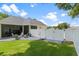 Well-maintained backyard featuring a white fence, fire pit area, and a screened-in patio for outdoor enjoyment at 3883 Se 51St Ct, Ocala, FL 34480
