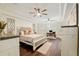 Bright bedroom with large windows, hardwood floors, two ceiling fans, and a tray ceiling at 3883 Se 51St Ct, Ocala, FL 34480