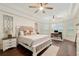 Large primary bedroom with hardwood floors, tray ceiling, seating area, and lots of natural light at 3883 Se 51St Ct, Ocala, FL 34480