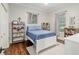 Cozy bedroom with a white frame bed, dark wood floors and decorative shelving at 3883 Se 51St Ct, Ocala, FL 34480