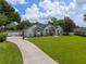 View of the charming single-story home showcasing the driveway, manicured lawn, and partial fence at 3883 Se 51St Ct, Ocala, FL 34480