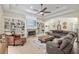 Spacious living room with a cozy stone fireplace, built-in bookshelves, and coffered ceiling at 3883 Se 51St Ct, Ocala, FL 34480