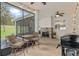 Large screened patio with a stone fireplace, grill, bar, and ceiling fans perfect for entertaining guests at 3883 Se 51St Ct, Ocala, FL 34480