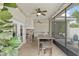 A serene screened patio with a stone fireplace, bar seating, and ceiling fans for comfortable outdoor living at 3883 Se 51St Ct, Ocala, FL 34480