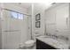 Modern bathroom featuring granite countertop, shower with glass door, and white tiled walls at 3993 Se 10Th Ave, Ocala, FL 34480