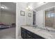Bathroom featuring double vanity with granite countertop and mirrors with access to another room at 3993 Se 10Th Ave, Ocala, FL 34480
