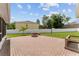 Large grassy backyard featuring a brick fire pit and a white fence at 4531 Se 27Th St, Ocala, FL 34480
