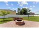 Spacious backyard featuring a circular brick firepit, a green lawn, and a white fence at 4531 Se 27Th St, Ocala, FL 34480