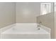 A close-up of the soaking tub with white tile and a chrome faucet at 4531 Se 27Th St, Ocala, FL 34480