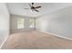 Spacious bedroom with neutral carpet, ceiling fan, and natural light from two windows at 4531 Se 27Th St, Ocala, FL 34480