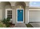 Close up of a charming front door, surrounded by a beautiful light fixture and fresh landscaping at 4531 Se 27Th St, Ocala, FL 34480
