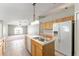Kitchen boasts wood cabinets, a kitchen island with sink, and a white refrigerator at 4531 Se 27Th St, Ocala, FL 34480