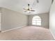 Open living room with neutral carpet, a ceiling fan and a large window for natural light at 4531 Se 27Th St, Ocala, FL 34480
