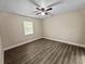 Clean bedroom with sleek flooring, neutral walls, ceiling fan, and window overlooking the property at 5 Bahia Circle Pl, Ocala, FL 34472