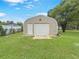 Spacious metal garage in backyard with roll-up door, extra storage, and side entry door at 5 Bahia Circle Pl, Ocala, FL 34472