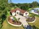 Aerial view of a home featuring a manicured lawn, and proximity to a golf course in a lush, green neighborhood at 5034 Nw 75Th Ave, Ocala, FL 34482