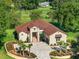 Aerial view showcasing the home's manicured lawn, stone facade, long driveway and proximity to the golf course at 5034 Nw 75Th Ave, Ocala, FL 34482