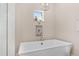 Large soaking tub between niche shelving and window, perfect for relaxing in this modern bathroom at 5034 Nw 75Th Ave, Ocala, FL 34482