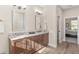 Double vanity bathroom with granite countertops, wood cabinets, and wood-look flooring at 5034 Nw 75Th Ave, Ocala, FL 34482