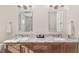 Bright bathroom showcasing dual sinks, granite countertops, wood-look flooring, and modern mirrors at 5034 Nw 75Th Ave, Ocala, FL 34482