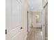 Hallway leading to the primary bathroom that has a tub, wood flooring, and neutral tones at 5034 Nw 75Th Ave, Ocala, FL 34482