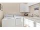 Well-organized laundry room with appliances, storage, sink, and counter space at 5034 Nw 75Th Ave, Ocala, FL 34482