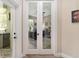A view through the glass doors into the light-filled home office with stylish decor at 5034 Nw 75Th Ave, Ocala, FL 34482