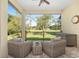 Cozy covered patio featuring comfortable wicker seating and a tranquil view of the verdant backyard at 5034 Nw 75Th Ave, Ocala, FL 34482