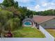 Aerial view of backyard featuring a screened-in pool and manicured lawn surrounded by mature trees at 5390 Se 15Th Ct, Ocala, FL 34480