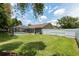 Wide backyard with a white fence, screened-in pool, and spacious lawn for endless outdoor enjoyment at 5390 Se 15Th Ct, Ocala, FL 34480