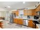 Well-lit kitchen featuring stainless steel appliances, wood cabinetry, and a tile backsplash at 5390 Se 15Th Ct, Ocala, FL 34480