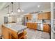 Traditional kitchen featuring wood cabinets, stainless steel appliances, and a peninsula with a breakfast bar at 5390 Se 15Th Ct, Ocala, FL 34480
