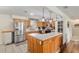 Well-lit kitchen featuring custom wood cabinetry, stainless steel appliances, and a tile countertop breakfast bar at 5390 Se 15Th Ct, Ocala, FL 34480
