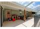 Large shaded lanai with ceiling fans, seating, and an entertainment area for outdoor relaxation at 5390 Se 15Th Ct, Ocala, FL 34480