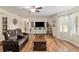 Bright living room with wood floors, a ceiling fan, and a large picture window with natural light at 5390 Se 15Th Ct, Ocala, FL 34480