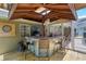 Outdoor bar area featuring a wooden countertop, seating, dart board and fan with view of screened-in patio at 5390 Se 15Th Ct, Ocala, FL 34480