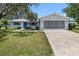 Charming single-story home featuring a screened garage and blue shutters, complemented by lush landscaping at 6495 Sw 109Th St, Ocala, FL 34476