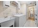 Bright laundry room includes washer, dryer, utility sink, and ample storage; tiled floor and access to nearby bathroom at 6495 Sw 109Th St, Ocala, FL 34476