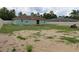 Large backyard with a wooden deck, partial grass coverage, and a surrounding fence at 7 Pecan Drive Loop, Ocala, FL 34472