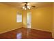 Bedroom with hardwood floors, ceiling fan, yellow walls, and an ensuite bathroom at 7 Pecan Drive Loop, Ocala, FL 34472