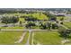 Aerial view of a community with houses, paddocks, and green spaces, horse facilities and nearby homes at 7054 Sw 64Th Ter, Ocala, FL 34476