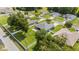 Aerial view of a house with a gray roof, green lawn, surrounded by neighboring homes and trees at 7054 Sw 64Th Ter, Ocala, FL 34476